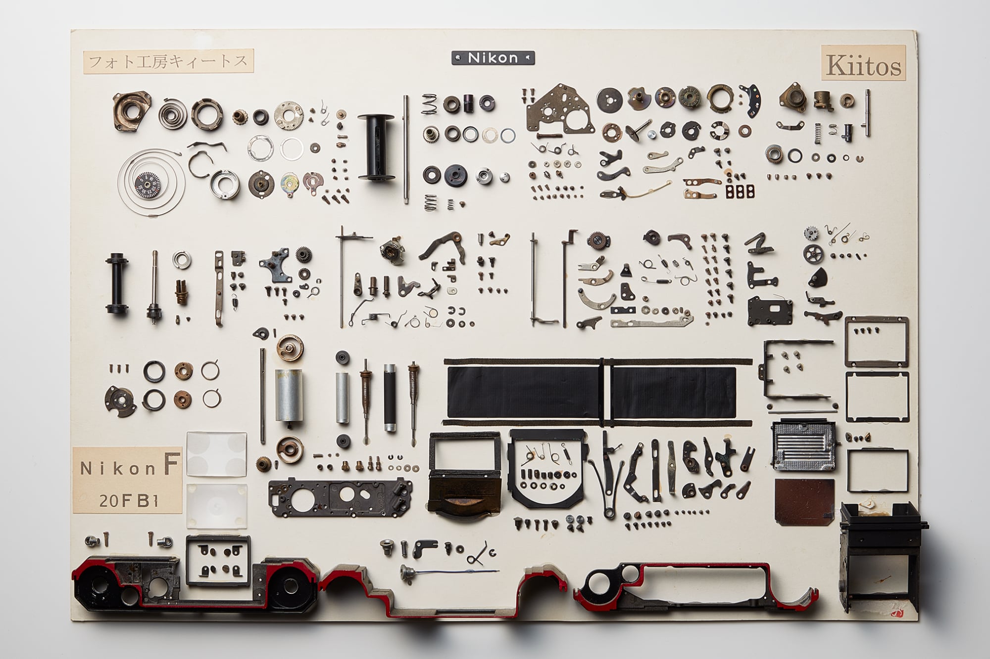 ニコンFを構成する部品の展開図。トップカバーなどの外殻を脱がすと現れる機構の中枢部は、ギアやカムなどの純粋な機械部品で構成されている。