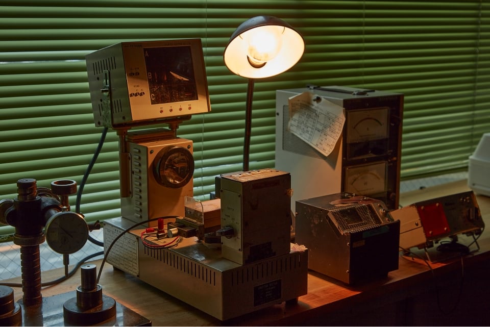 カメラが分解中の状態でシャッター速度を計測できる試験機を使って全速確認し、部品の不具合などを修正・調整している。