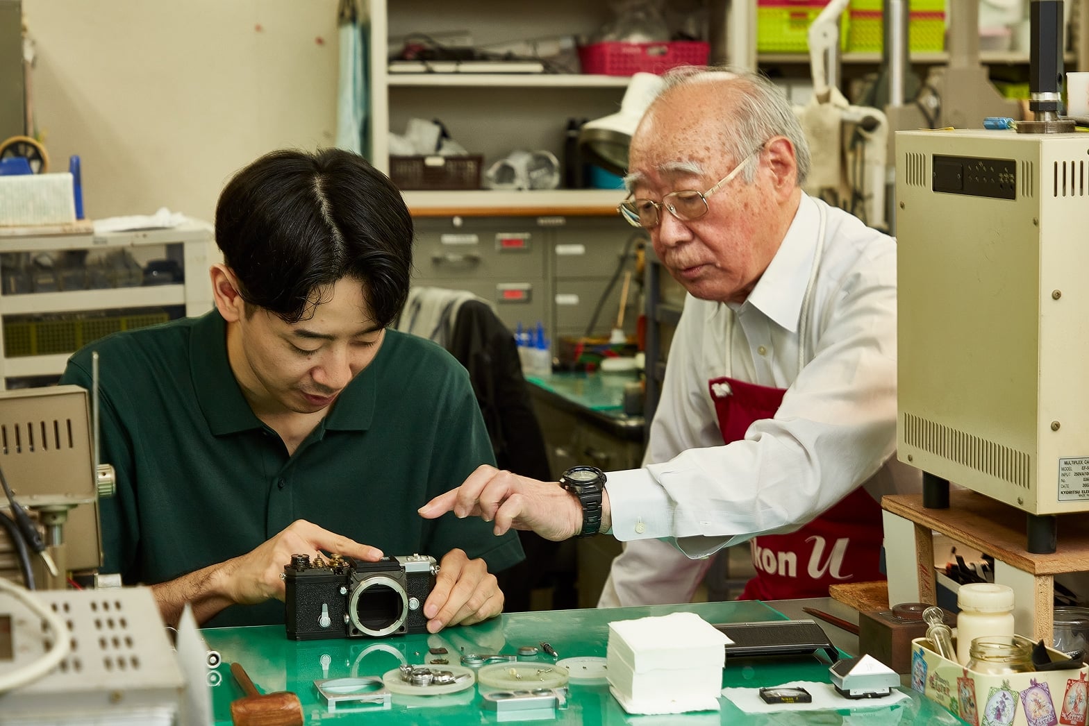 ニコンF修理のマイスターである技術顧問の菊地誠孝さんの指導を受けるU.C.Sの白戸太公さん。分解の順番や工具のセレクトに加え「そこ、固いから気をつけてね」などカメラを傷つけないように注意すべきポイントも指摘しながら実習が続く。