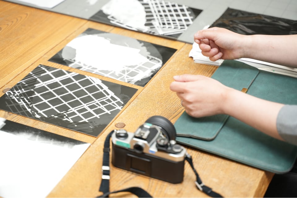 吉田先生が暗室で指導するフォトグラム。印画紙の上に物を置いたり水を掛けたりして露光する実験的な表現。